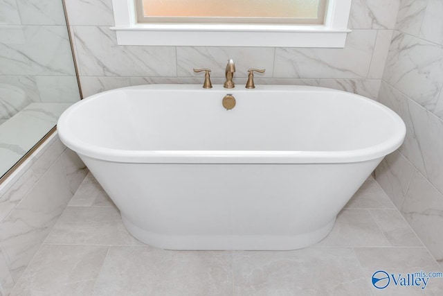 bathroom featuring a soaking tub, tile patterned floors, and tile walls