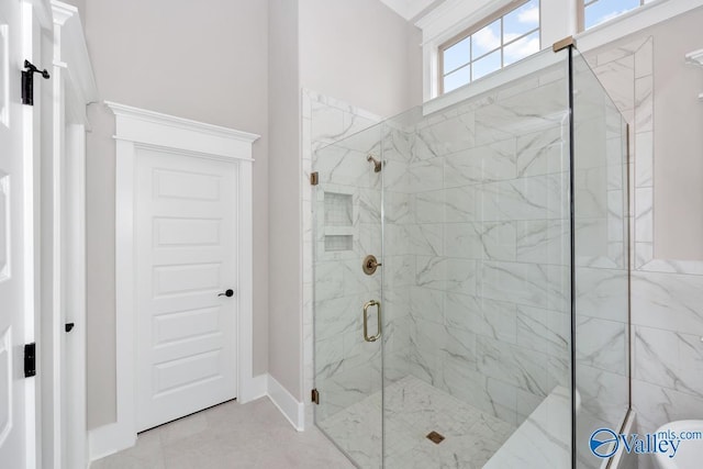 full bath with a shower stall and baseboards