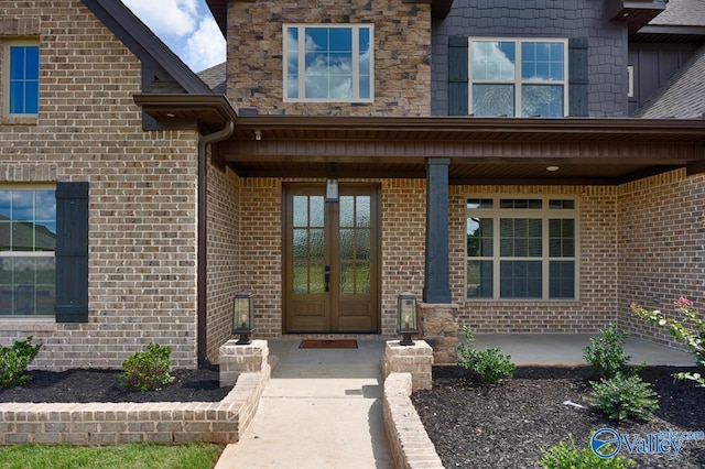 view of exterior entry with french doors and brick siding