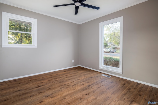 unfurnished room with dark wood-type flooring, ceiling fan, plenty of natural light, and ornamental molding