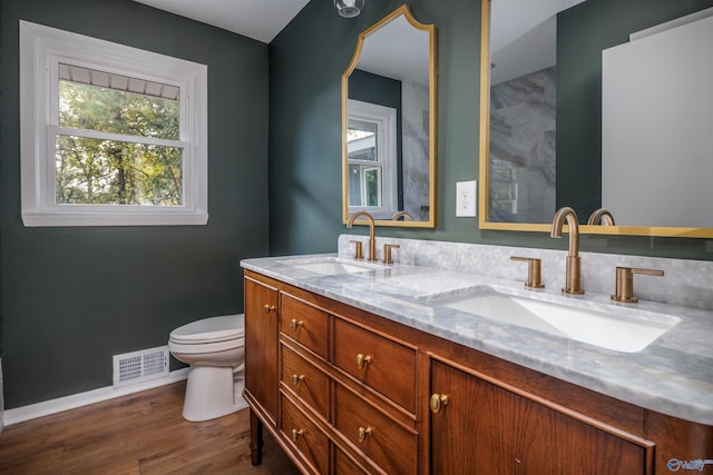 bathroom with toilet, vanity, and hardwood / wood-style floors