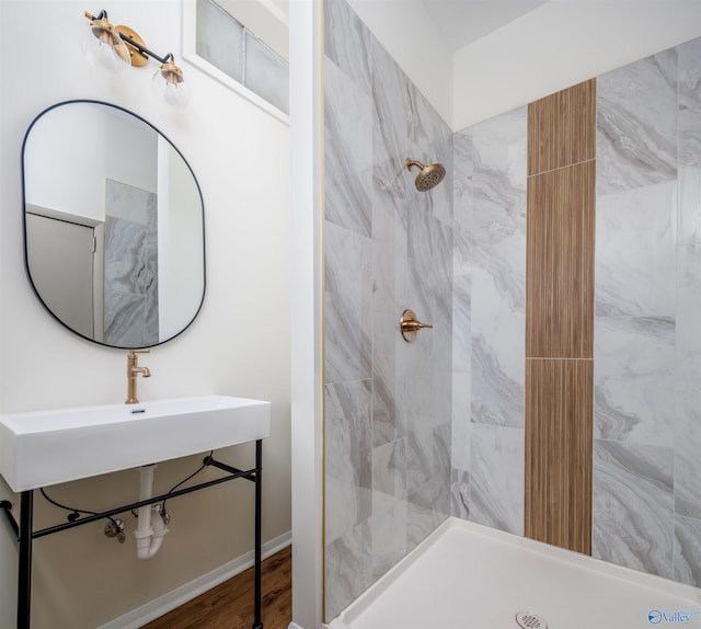 bathroom with hardwood / wood-style floors and a tile shower