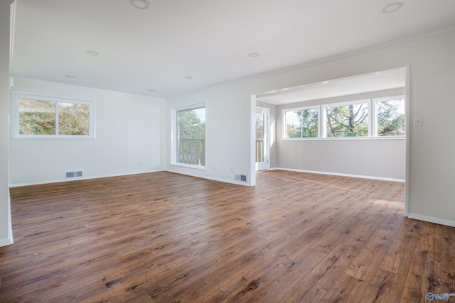 empty room with ornamental molding and dark hardwood / wood-style flooring