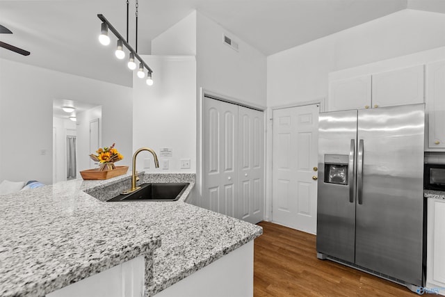 kitchen with visible vents, dark wood finished floors, a sink, white cabinets, and stainless steel fridge