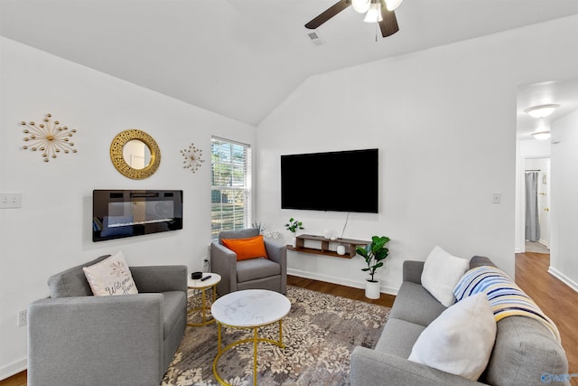 living room featuring a ceiling fan, wood finished floors, visible vents, baseboards, and vaulted ceiling