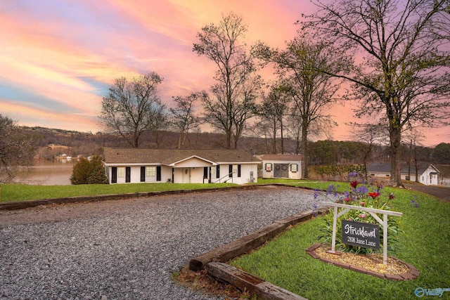 ranch-style home with a yard, driveway, and stucco siding