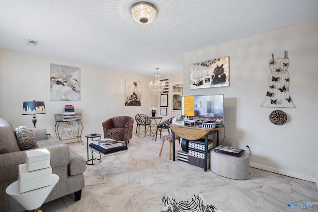 living area with a textured ceiling, a notable chandelier, visible vents, baseboards, and marble finish floor