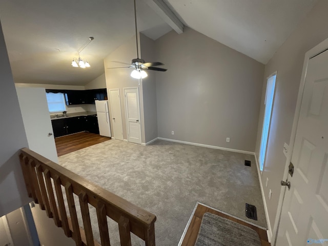 carpeted living room featuring ceiling fan with notable chandelier, high vaulted ceiling, and beamed ceiling