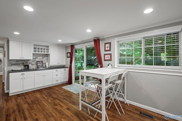 228 George Byrd Dr, Owens Cross Roads, AL 35763 - kitchen with ornamental molding, dark wood finished floors, white cabinetry, dark countertops, and tasteful backsplash