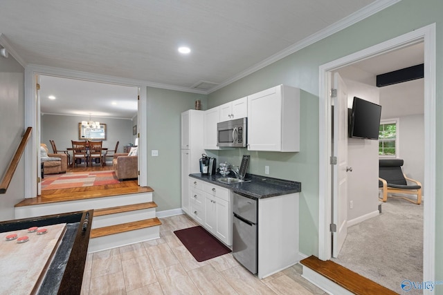 228 George Byrd Dr, Owens Cross Roads, AL 35763 - kitchen featuring stainless steel appliances, dark countertops, white cabinetry, a chandelier, and ornamental molding