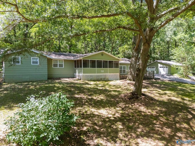 228 George Byrd Dr, Owens Cross Roads, AL 35763 - view of front of house featuring a sunroom, a garage, and an outbuilding