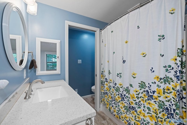 228 George Byrd Dr, Owens Cross Roads, AL 35763 - bathroom featuring vanity, toilet, wood finished floors, and a shower with shower curtain