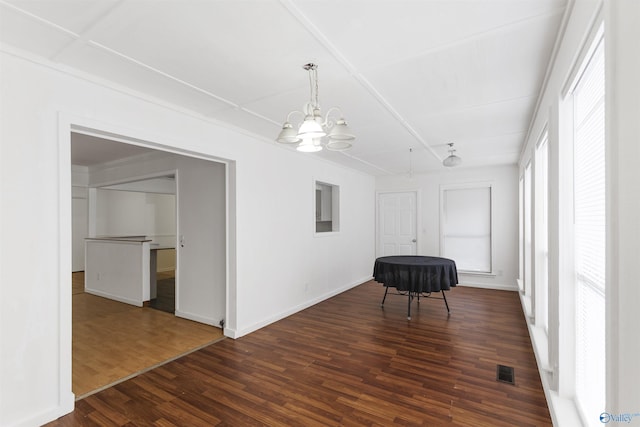 unfurnished room with dark hardwood / wood-style flooring and a notable chandelier