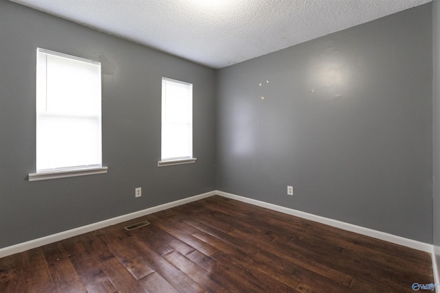 spare room with dark wood-type flooring and a textured ceiling