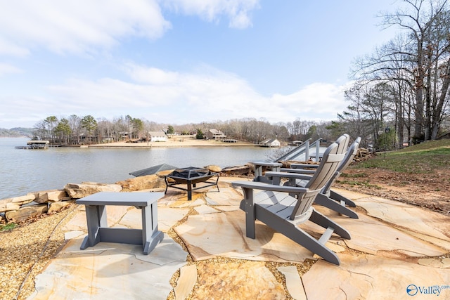 view of patio with a water view and an outdoor fire pit