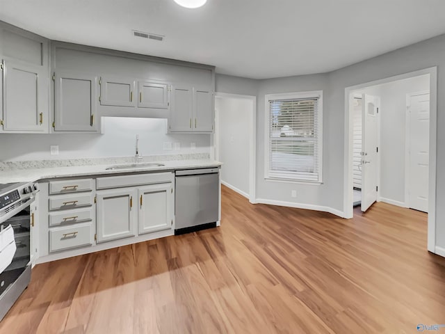107 Patra Dr, Madison, AL 35758 - kitchen featuring appliances with stainless steel finishes, light wood finished floors, and gray cabinetry