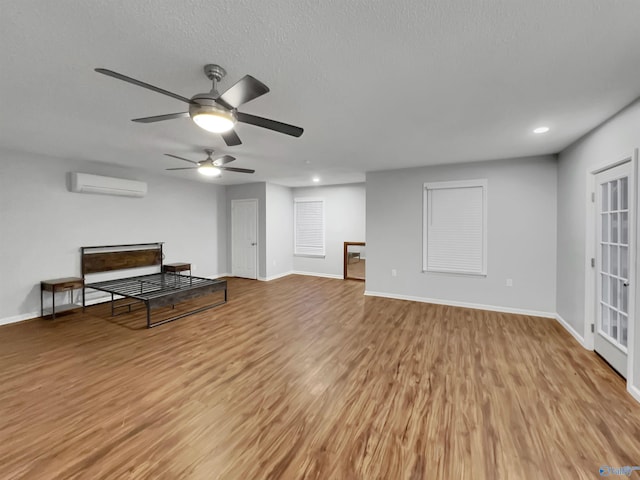 107 Patra Dr, Madison, AL 35758 - unfurnished living room featuring an AC wall unit, light wood finished floors, recessed lighting, a ceiling fan, and a textured ceiling