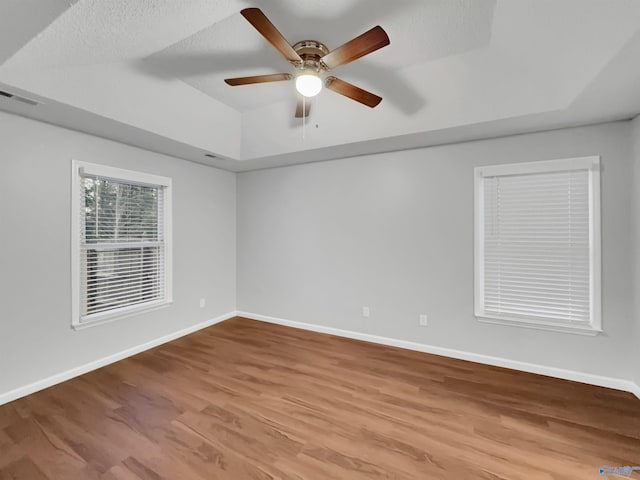 107 Patra Dr, Madison, AL 35758 - empty room with wood finished floors, a ceiling fan, vaulted ceiling, a textured ceiling, and a tray ceiling