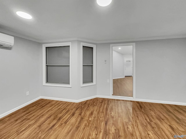 107 Patra Dr, Madison, AL 35758 - unfurnished room featuring light wood-type flooring, built in shelves, crown molding, and a wall mounted air conditioner