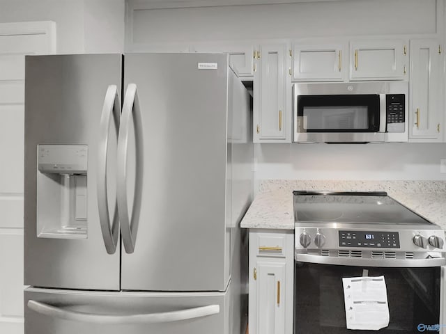 107 Patra Dr, Madison, AL 35758 - kitchen with stainless steel appliances, white cabinetry, and light stone counters