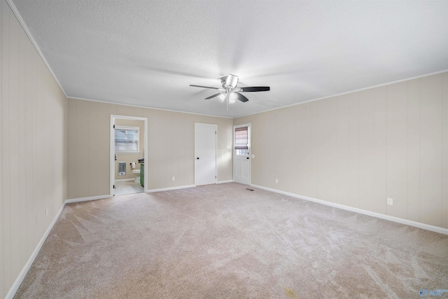 carpeted empty room featuring crown molding, ceiling fan, and a textured ceiling