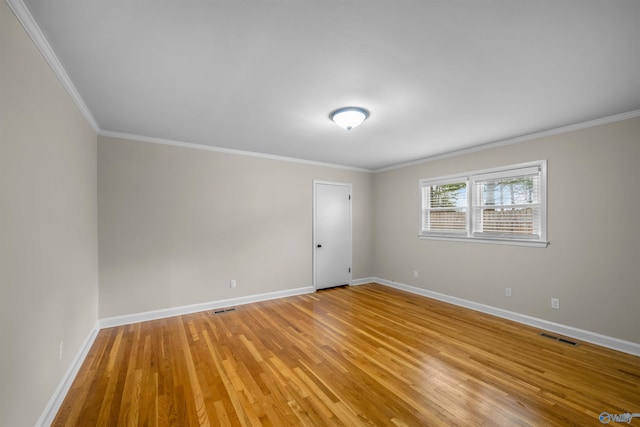 empty room with crown molding and light wood-type flooring