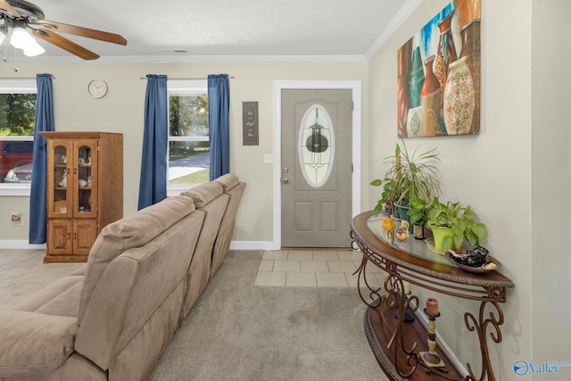 foyer with ornamental molding, ceiling fan, and light colored carpet