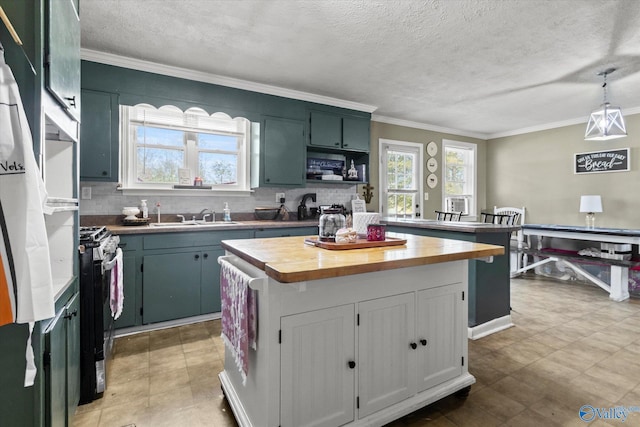 kitchen featuring sink, wood counters, pendant lighting, decorative backsplash, and a kitchen island