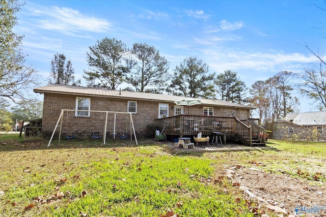 rear view of house with a yard and a wooden deck