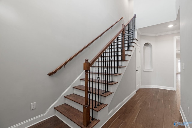 stairs with hardwood / wood-style flooring and crown molding