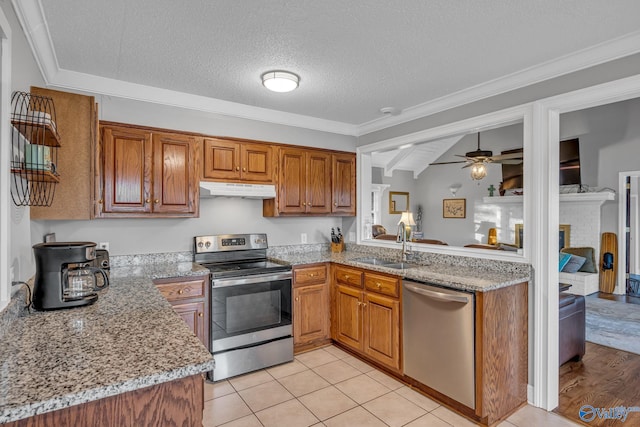 kitchen featuring stainless steel appliances, sink, ceiling fan, a textured ceiling, and light tile patterned floors