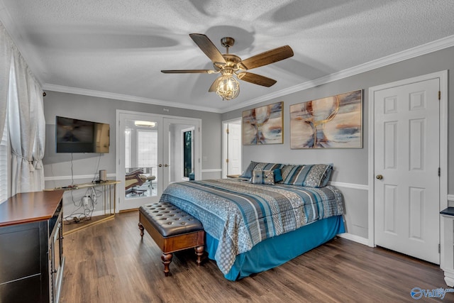 bedroom with a textured ceiling, dark hardwood / wood-style flooring, ornamental molding, and ceiling fan