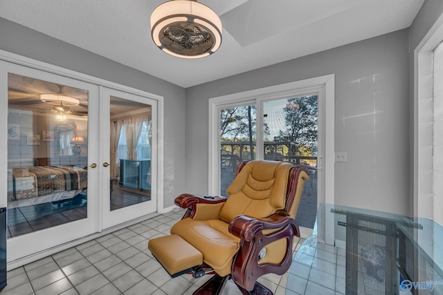 sitting room featuring light tile patterned flooring, a textured ceiling, and french doors