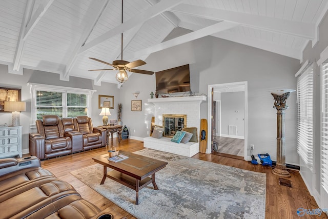 living room featuring high vaulted ceiling, wood-type flooring, ceiling fan, and a brick fireplace