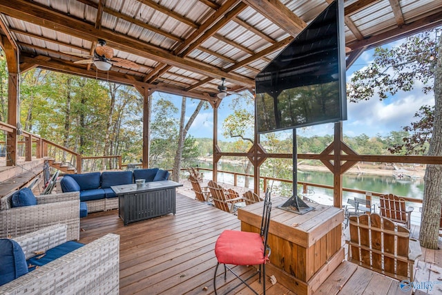 wooden terrace with outdoor lounge area, a water view, and ceiling fan