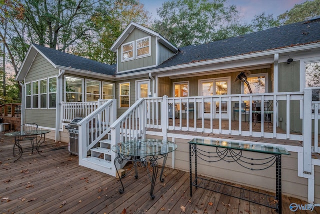 deck at dusk featuring a sunroom