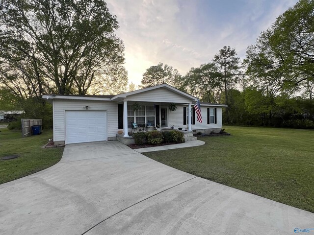 ranch-style house with concrete driveway, a porch, a front lawn, and an attached garage