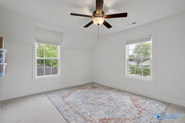 additional living space with healthy amount of natural light, ceiling fan, baseboards, carpet flooring, and lofted ceiling