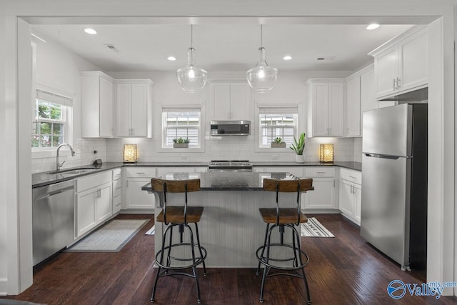 kitchen featuring stainless steel appliances, healthy amount of natural light, a sink, white cabinets, and recessed lighting