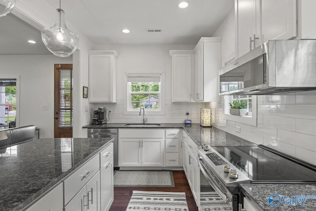 kitchen with appliances with stainless steel finishes, a sink, white cabinets, dark wood finished floors, and recessed lighting