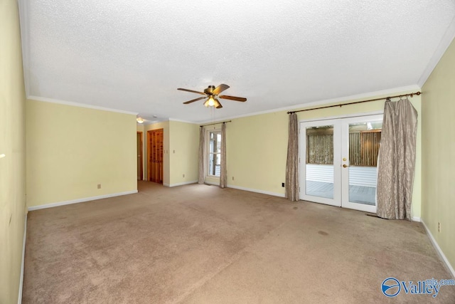 carpeted empty room featuring crown molding, a textured ceiling, a ceiling fan, french doors, and baseboards