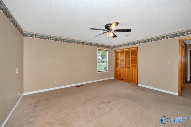 unfurnished bedroom with a closet, baseboards, carpet flooring, a ceiling fan, and visible vents
