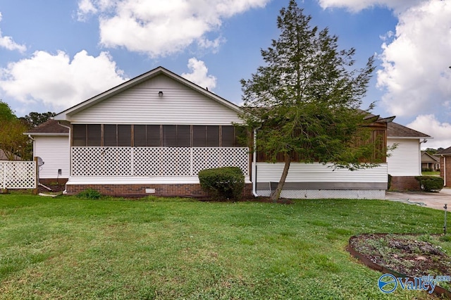 view of side of property featuring a sunroom and a lawn