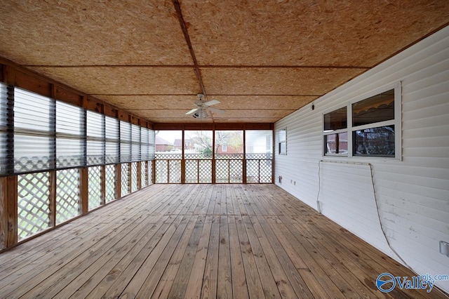unfurnished sunroom featuring a ceiling fan and a healthy amount of sunlight