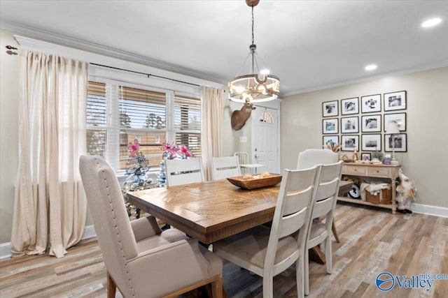 dining room featuring light hardwood / wood-style flooring, an inviting chandelier, and ornamental molding