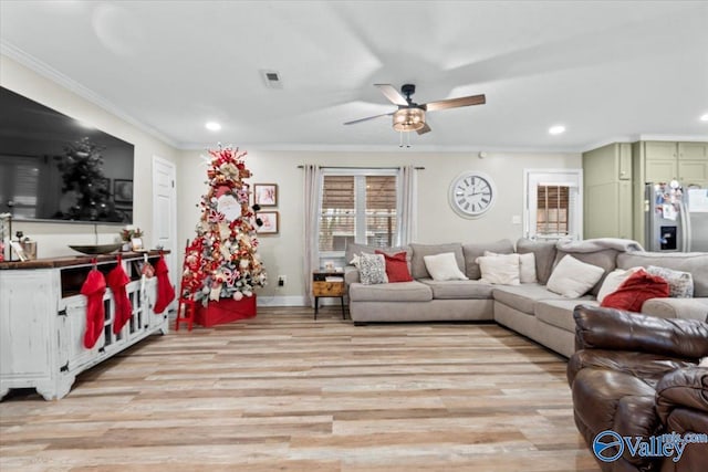 living room with light hardwood / wood-style floors, ceiling fan, and crown molding