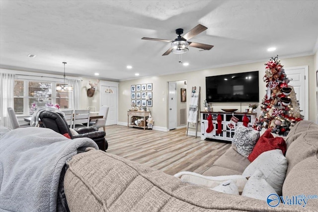 living room with ceiling fan, crown molding, and light hardwood / wood-style floors