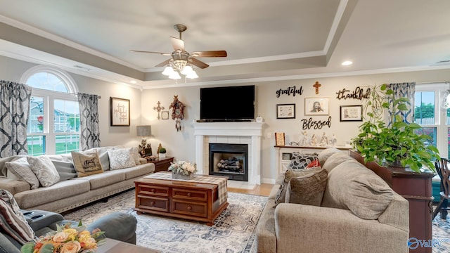 112 Bullard Rd, Hazel Green, AL 35750 - living room featuring a tray ceiling, healthy amount of natural light, a ceiling fan, a tile fireplace, and ornamental molding
