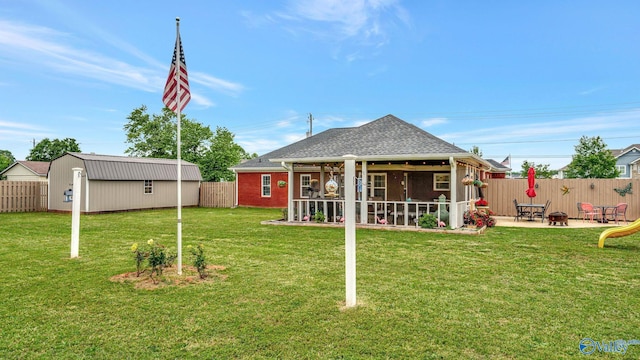 112 Bullard Rd, Hazel Green, AL 35750 - back of property featuring a patio area, a sunroom, an outbuilding, and a shingled roof