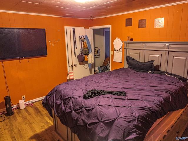 bedroom featuring crown molding and wood-type flooring